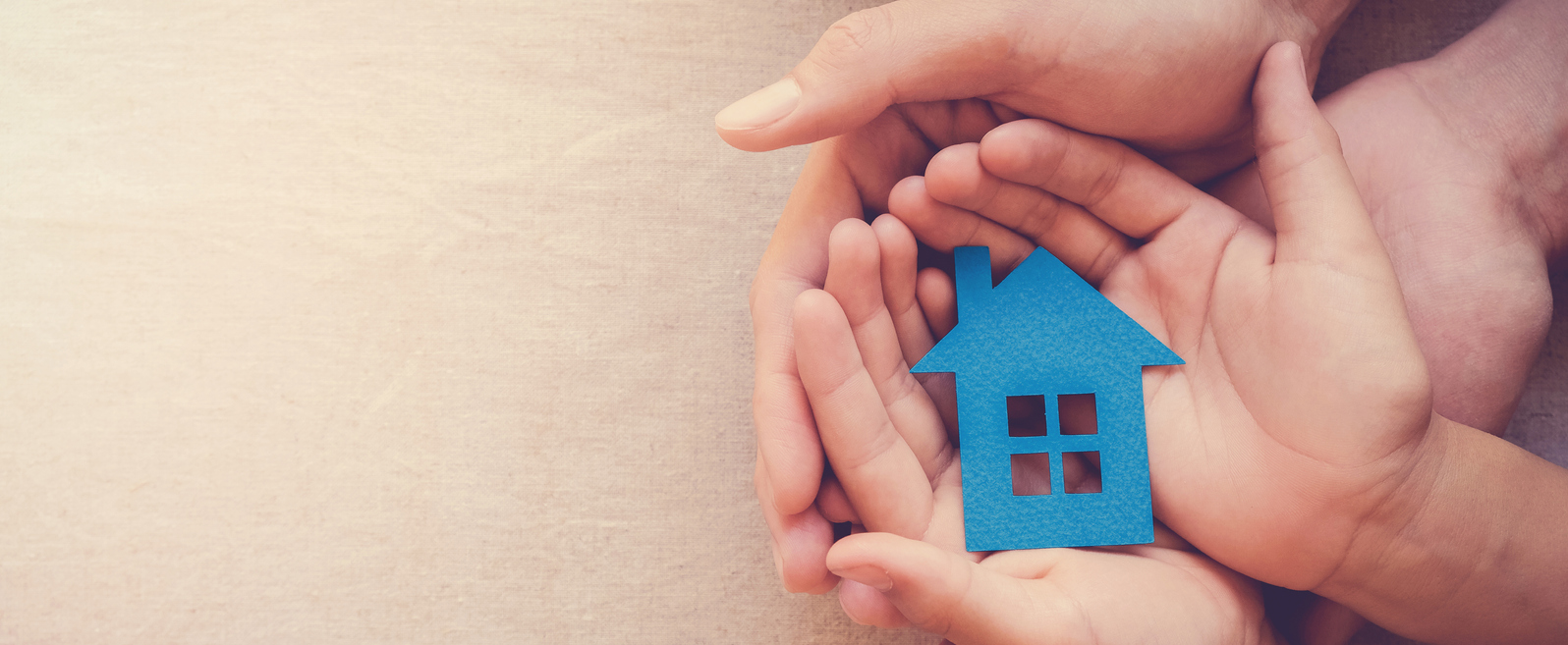 Adult and child hands holding blue paper house for family home and homeless shelter concept Adult and child hands holding blue paper house for family home and homeless shelter concept